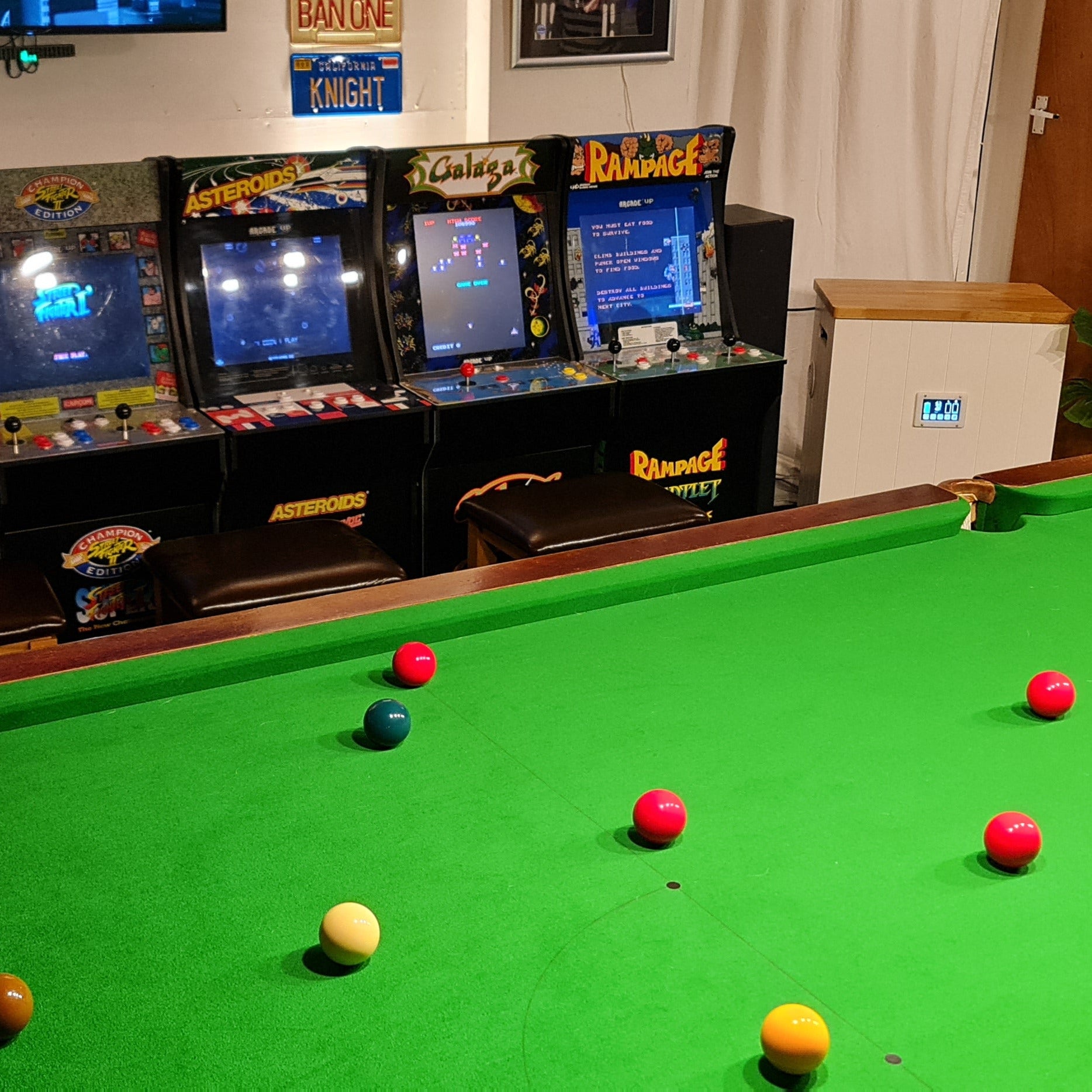 Snooker table with billiard balls in a room with arcade machines. All powered by a solar generator