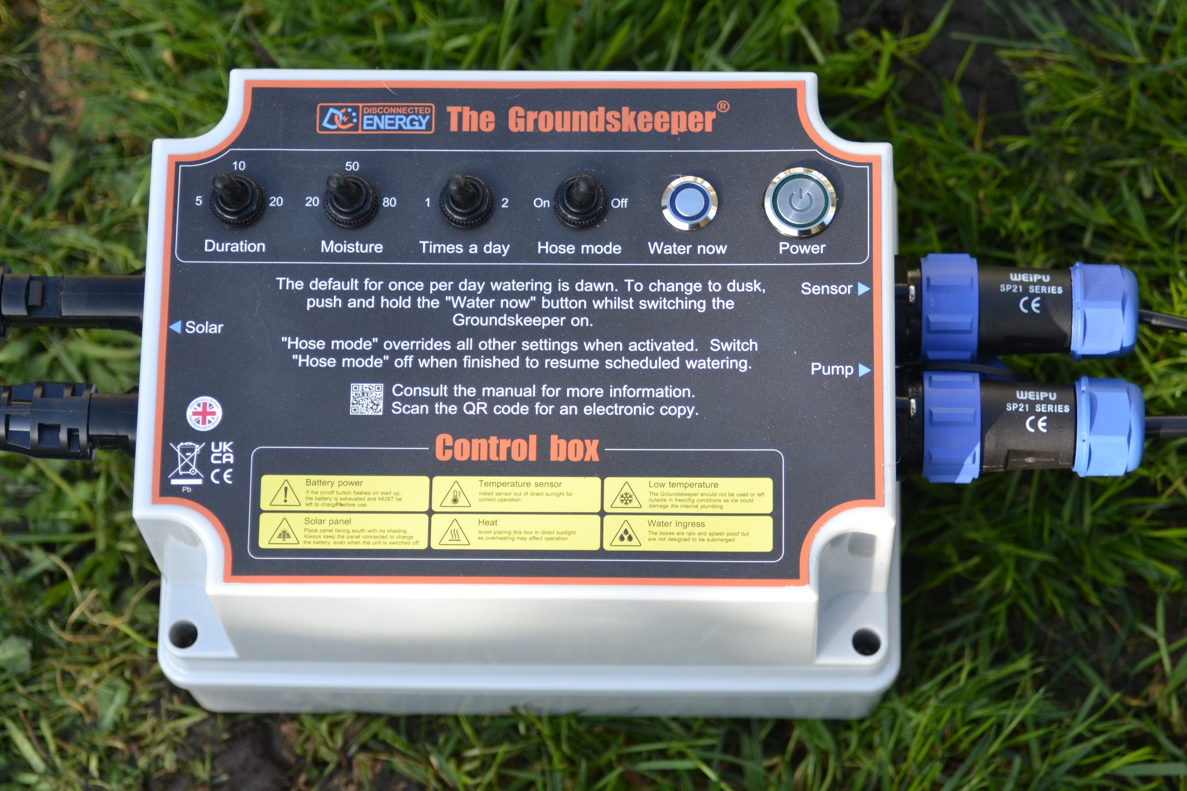 Control box for The Groundskeeper garden water management system on grass. 